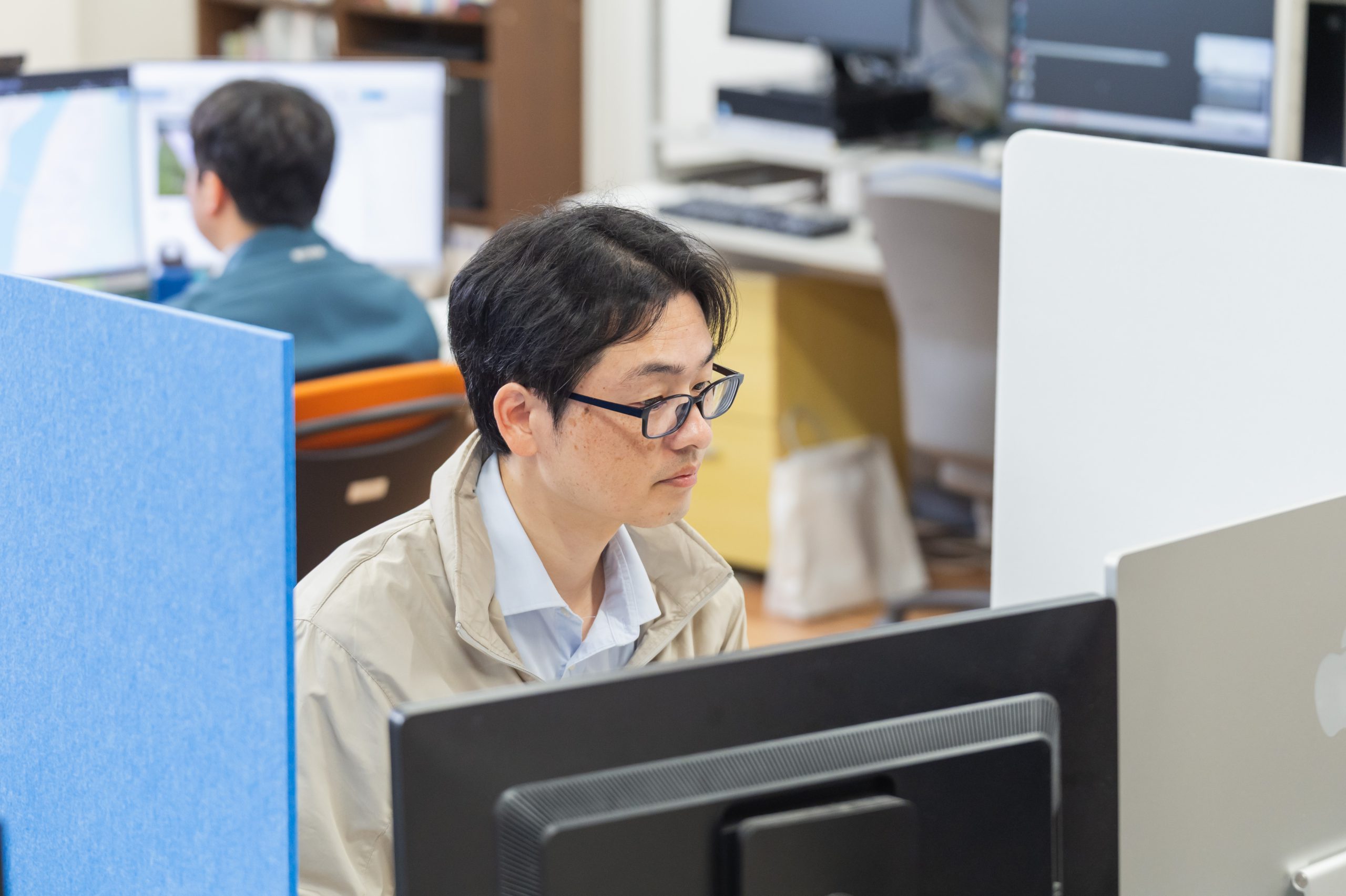 パソコンをみつめるアークの社員